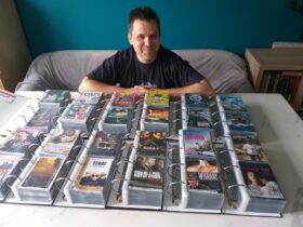 ulotki filmowe kolekcja. Mężczyzna siedzący przed segregatorami ze zbiorami ulotek