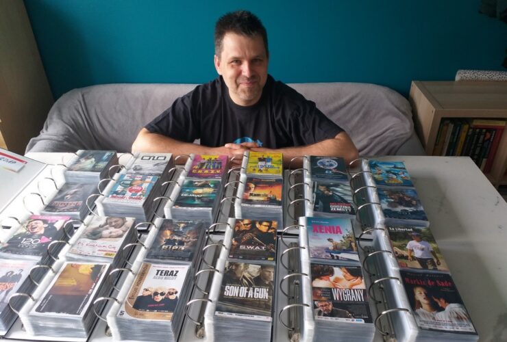 ulotki filmowe kolekcja. Mężczyzna siedzący przed segregatorami ze zbiorami ulotek