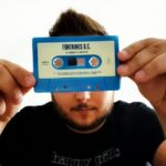 Mężczyzna trzymający przed sobą kasetę