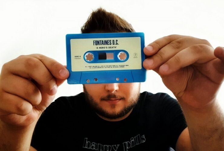 Mężczyzna trzymający przed sobą kasetę