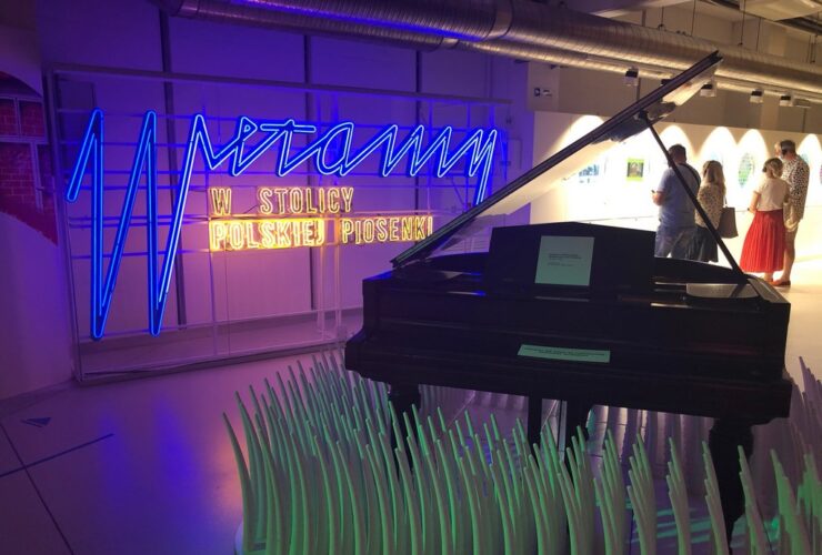 Duży napis Muzeum Polskiej Piosenki w Opolu. Obok fortepian.