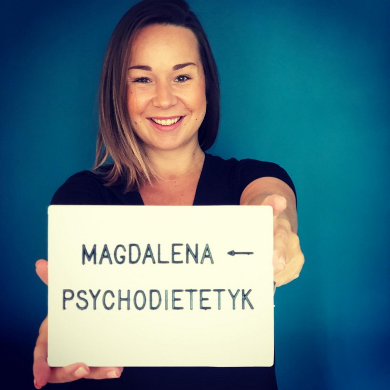 Kobieta trzymająca przed sobą kartkę z napisem: Magdalena - psychodietetyk