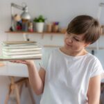 Milena - introligatorka trzyma w dłoni kilka notesów. Przygląda im się. Jest uśmiechnięta