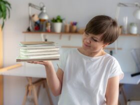 Milena - introligatorka trzyma w dłoni kilka notesów. Przygląda im się. Jest uśmiechnięta