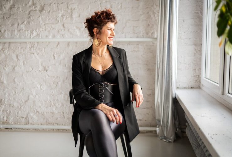 Ola braffierka siedzi na krześle ubrana w czarny strój.