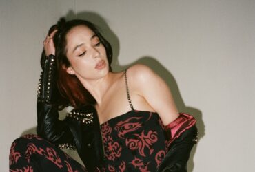 Sonia Zając siedzi przy ścianie, podpiera głowę o rękę