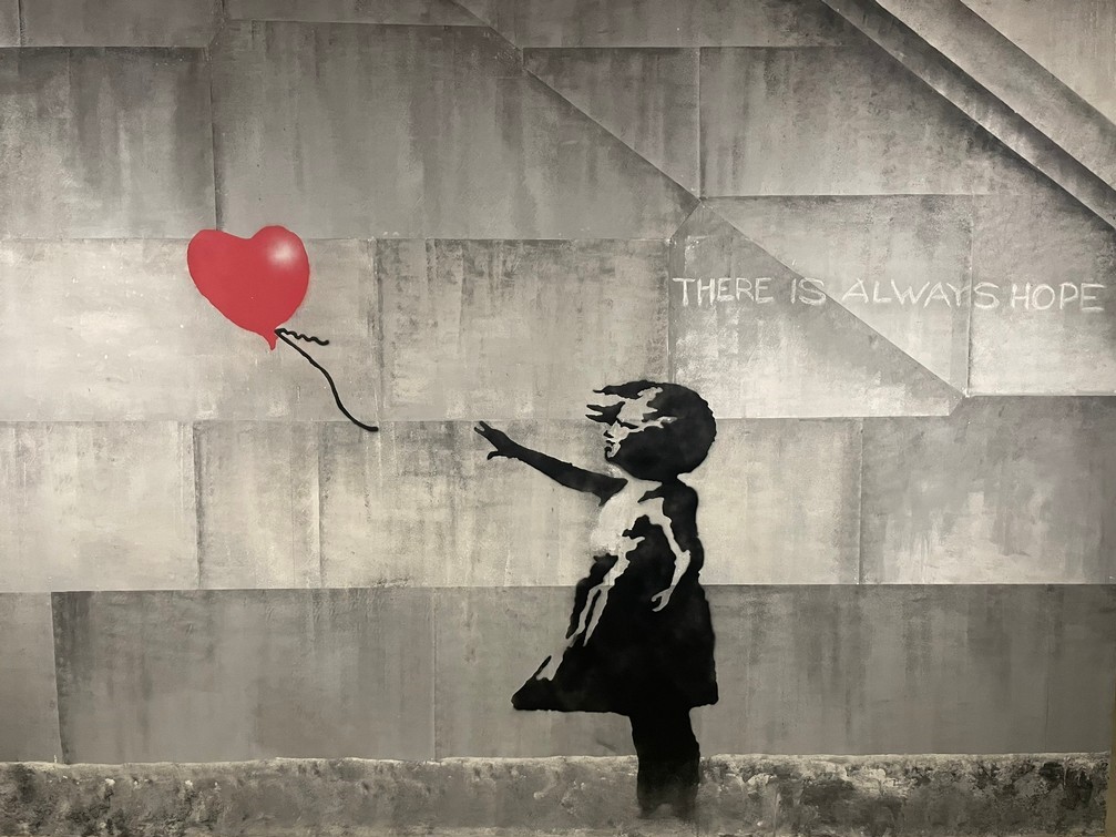 Dziewczynka wyciągająca rękę za balonem, napis: there is always a hope