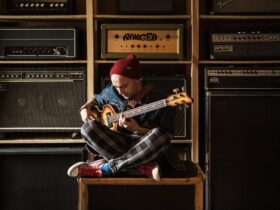 Damian Sikorski siedzi na głośniku z gitarą